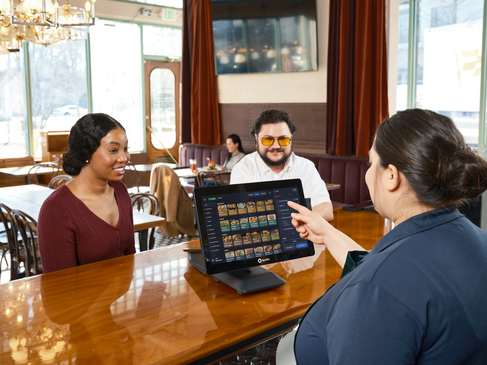 Bedienung nimmt an der Bar eine Bestellung am Touchscreen-Kassensystem auf